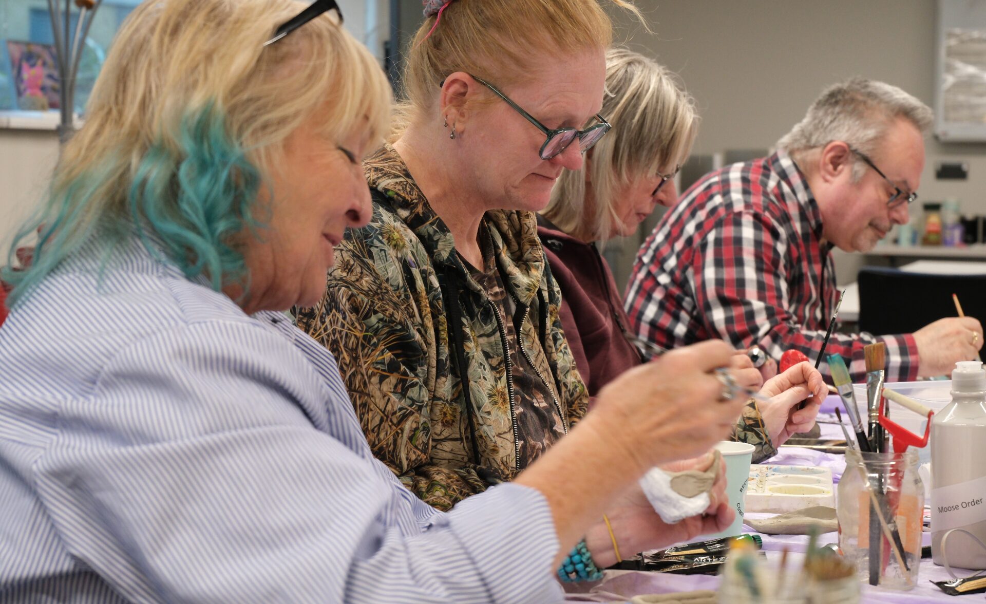 Peer tutor and recovery college students engage in a pottery workshop.