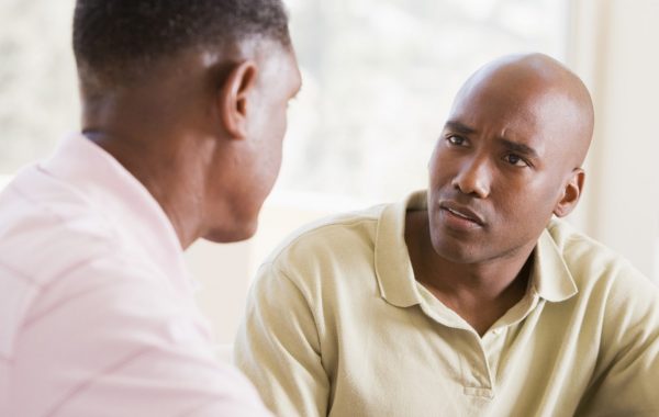 Close up head and shoulder shot of two seated people facing each other in conversation and dressed informally