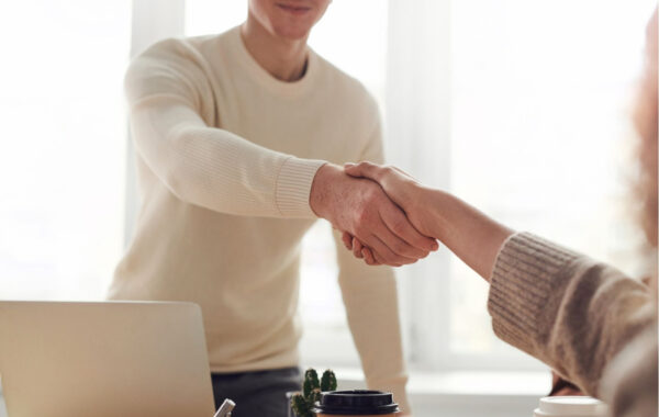 Photo of a handshake between two people across a table