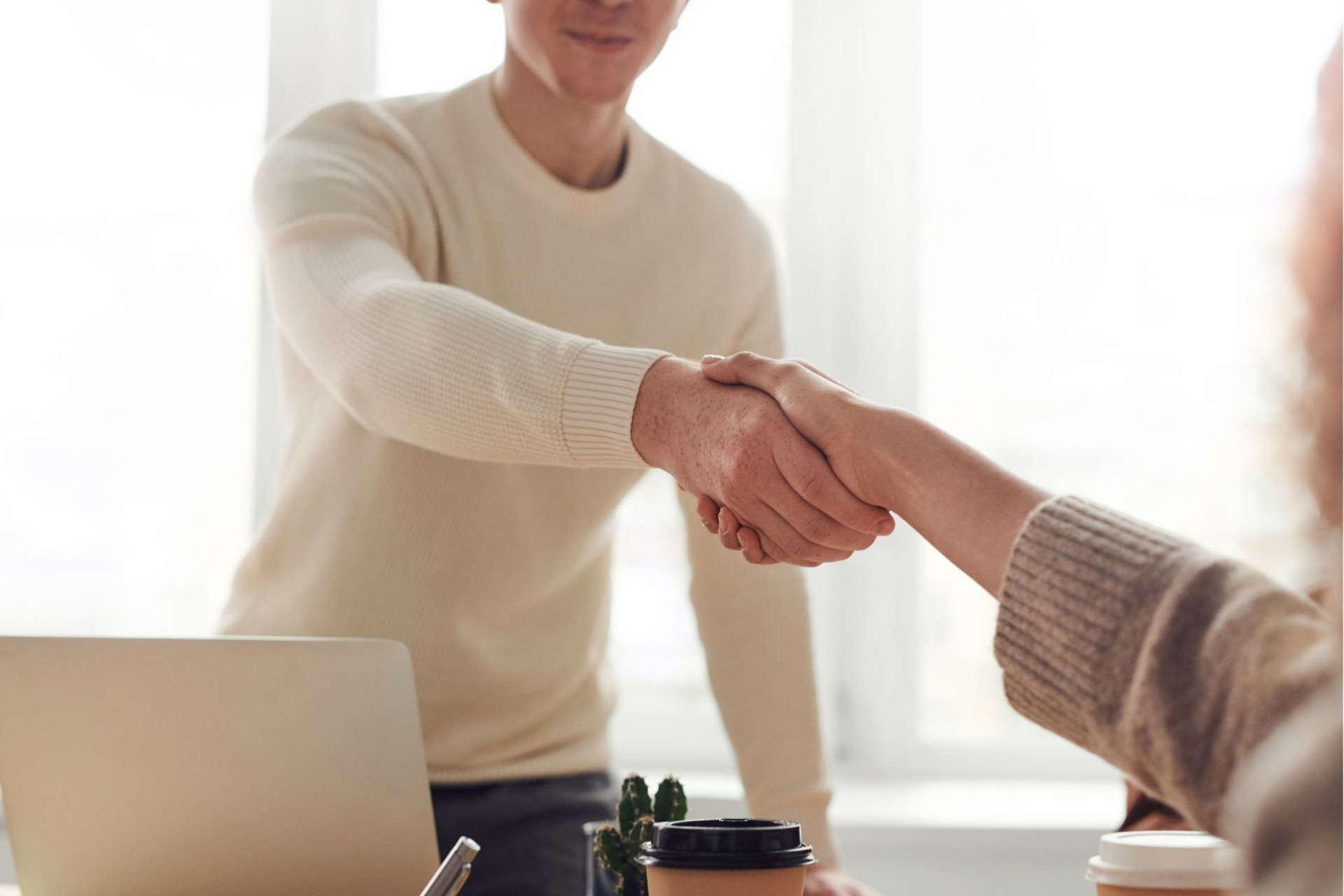 Photo of a handshake between two people across a table