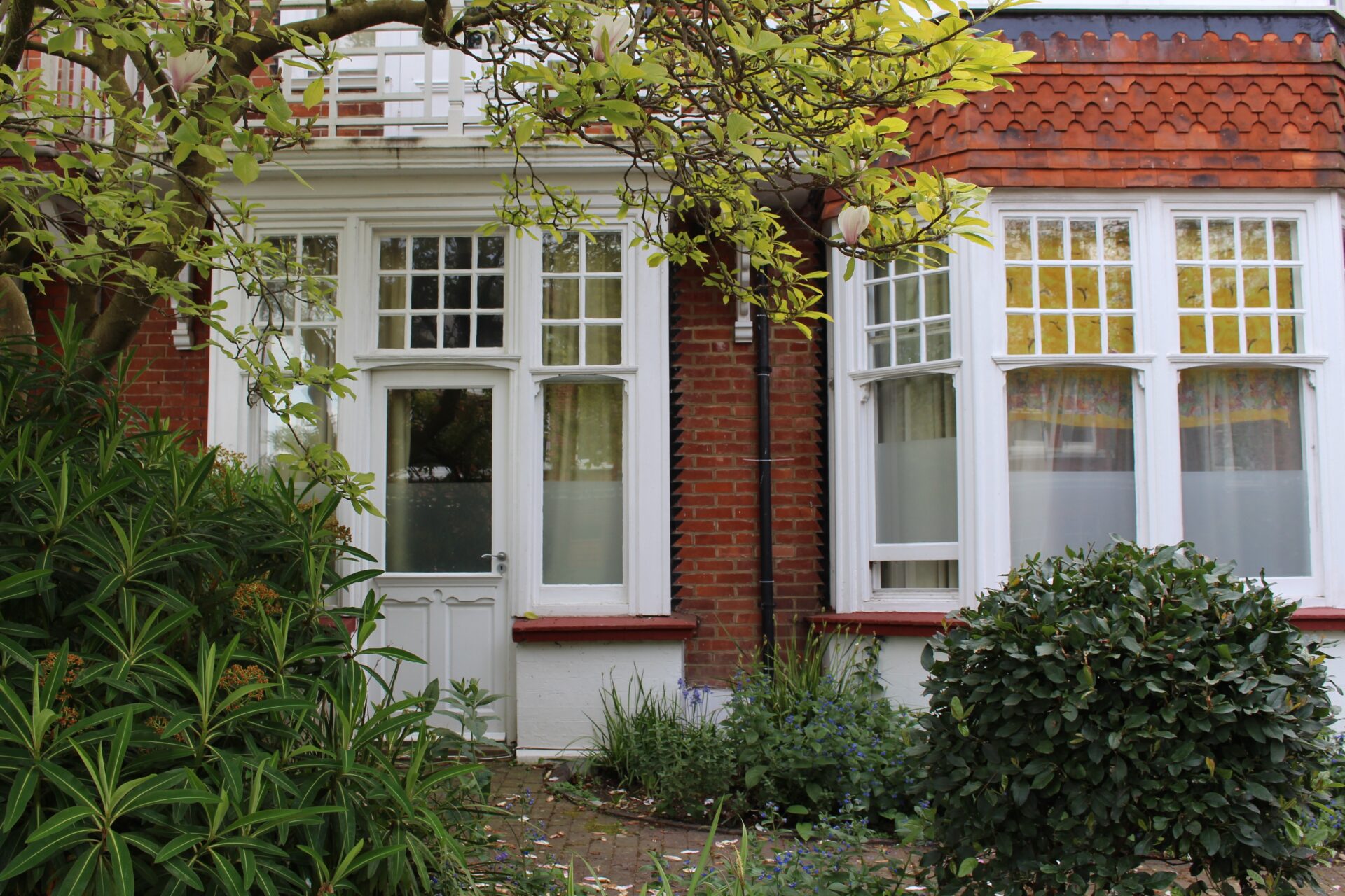 a red brick house surrounded by trees and shrubs