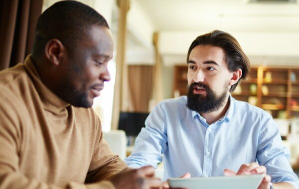 Photo depicting a conversation between two people who are sat at a table