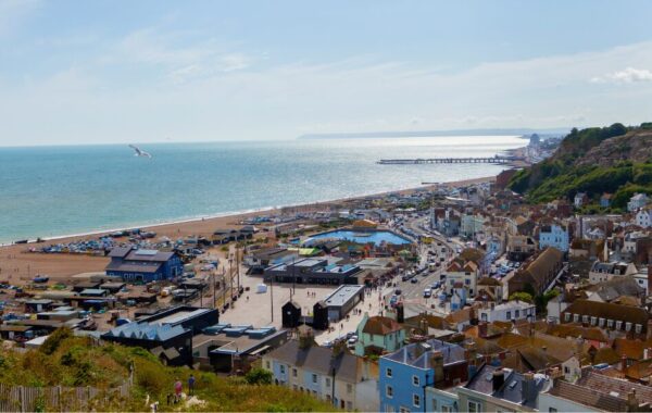 A landscape image of Hastings town and seafront. The sea is in the background.