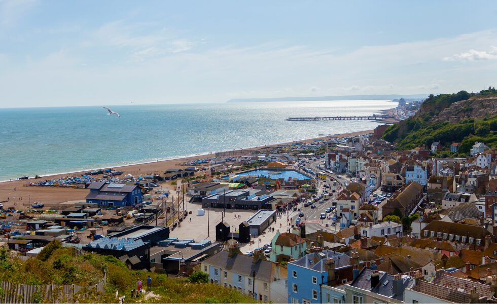 A landscape image of Hastings town and seafront. The sea is in the background.