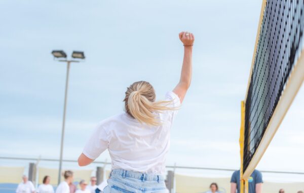A Southdown colleague playing beach volleyball, raising an arm in celebration. The image reflects Southdown’s recognition as one of the UK’s Top 30 Employers for Working Families, highlighting teamwork, inclusion, wellbeing, and a supportive workplace culture.