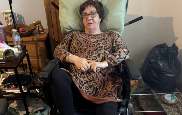 A client lying in their wheelchair.