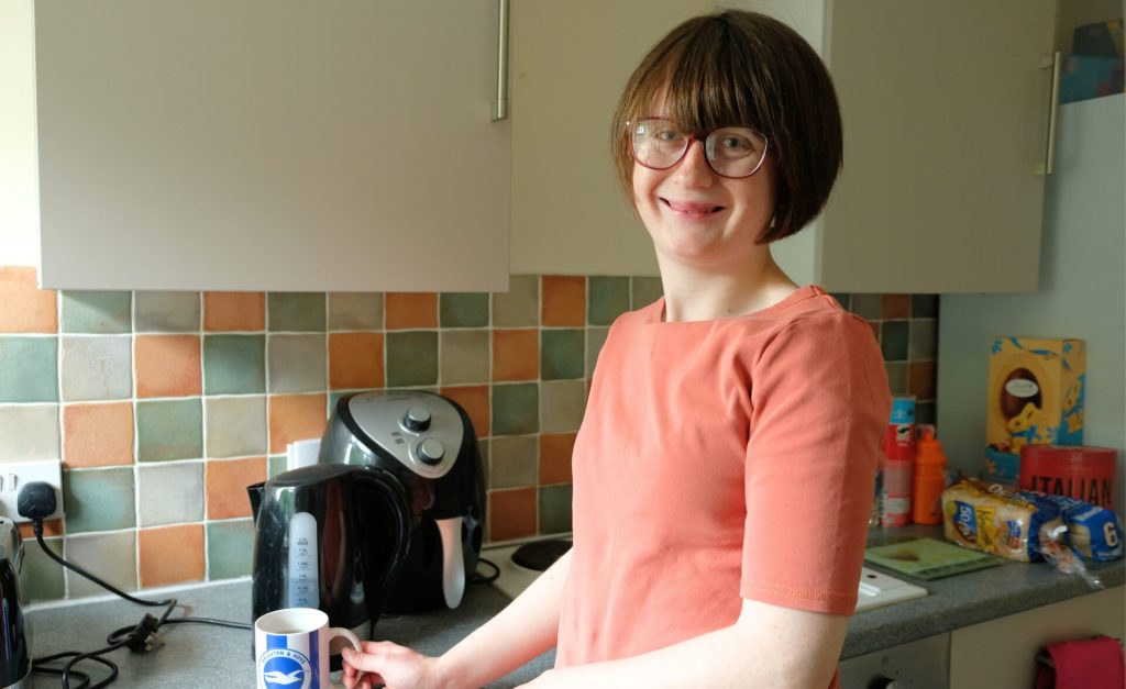 A woman is making a hot drink in the kitchen