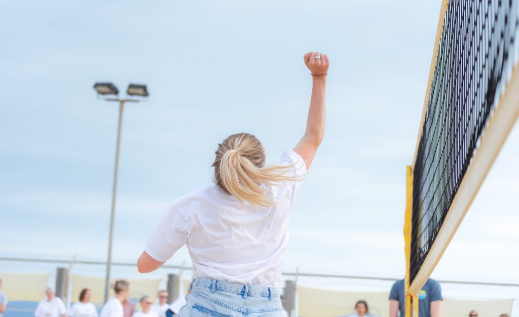 A Southdown colleague playing beach volleyball, raising an arm in celebration. The image reflects Southdown’s recognition as one of the UK’s Top 30 Employers for Working Families, highlighting teamwork, inclusion, wellbeing, and a supportive workplace culture.