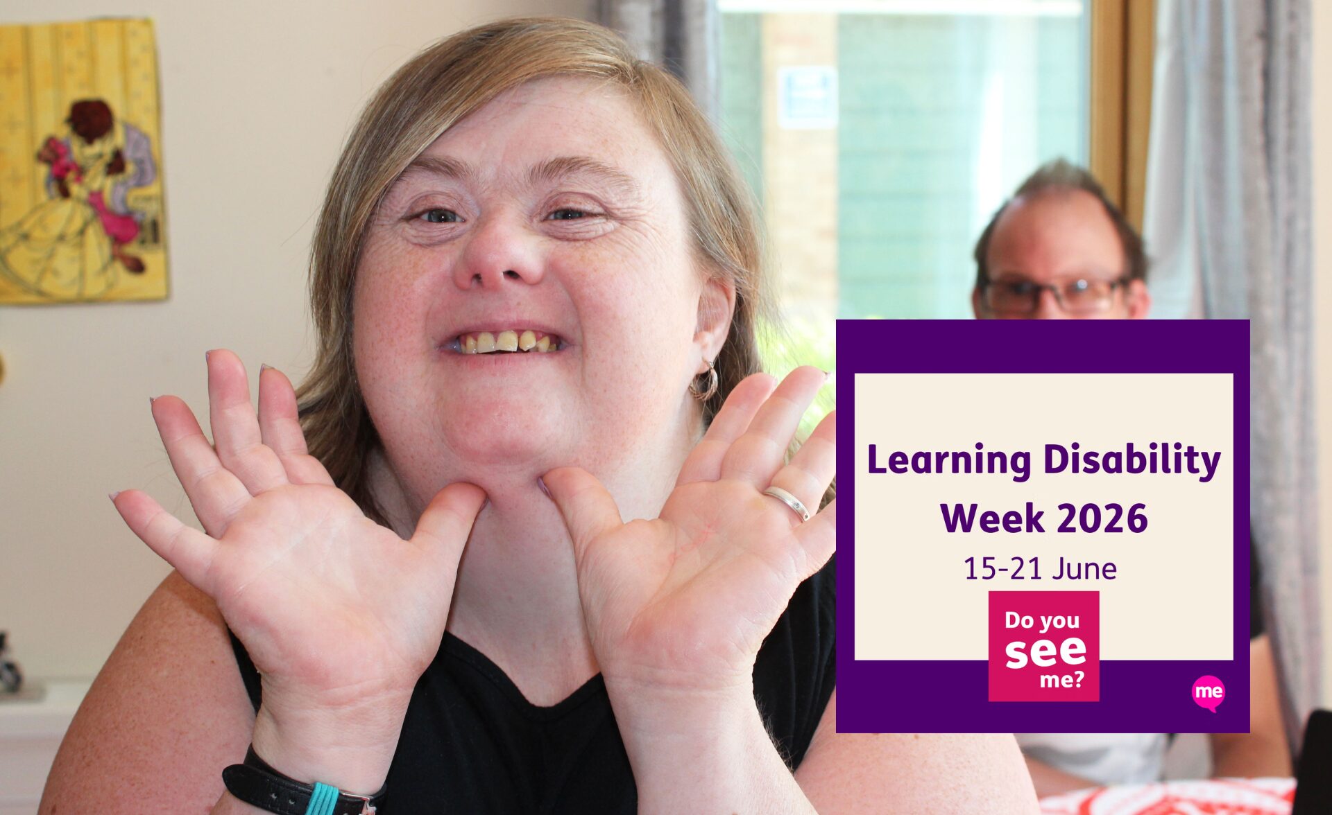 A smiling woman with a learning disability looks directly at the camera, holding her hands up beside her face in a cheerful pose. Another person is softly out of focus in the background. A purple graphic overlay reads “Learning Disability Week 2026, 15–21 June” alongside the campaign message “Do you see me?”.