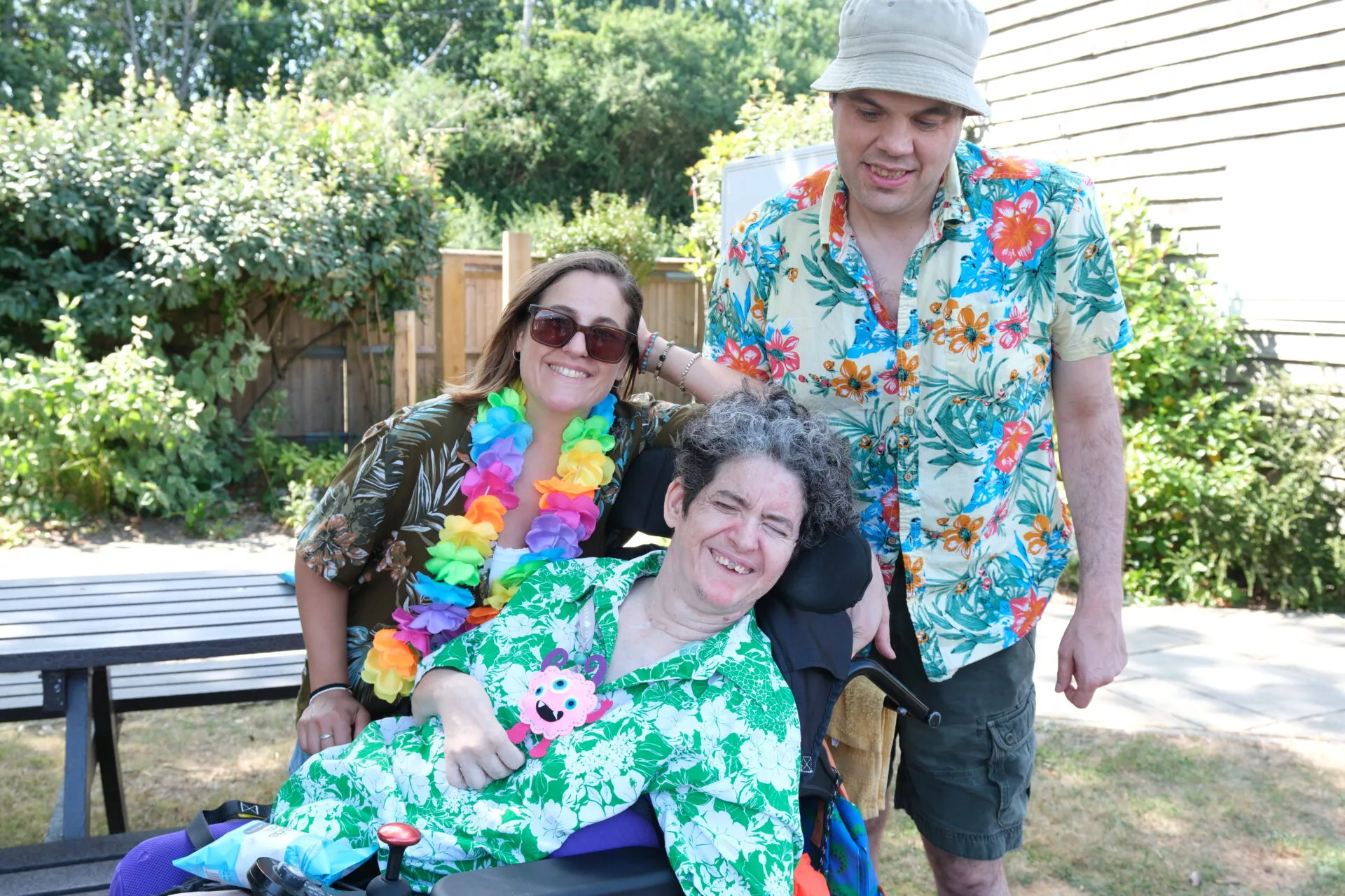 Two clients and a staff member smile to the camera.
